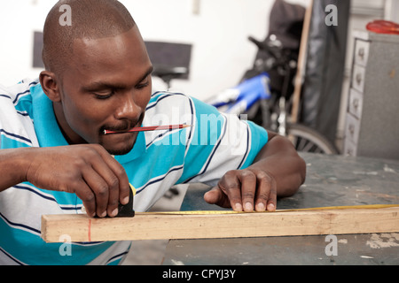 L'uomo africano effettuare misurazioni in un workshop Foto Stock