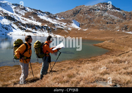 La Svizzera centrale delle Alpi della Val Bregaglia Cantone dei Grigioni gli escursionisti guardando su una mappa sul bordo di un lago sotto Septimer Pass Foto Stock