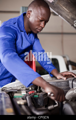 African uomo al lavoro su un auto a motore Foto Stock