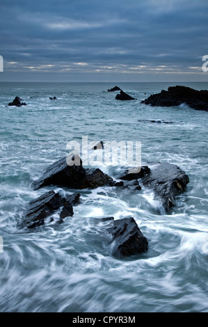 Marea volute intorno a rocce a Hartland Quay Foto Stock