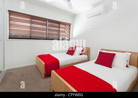 Elegante camera doppia con due letti in una moderna casa australiana Foto Stock