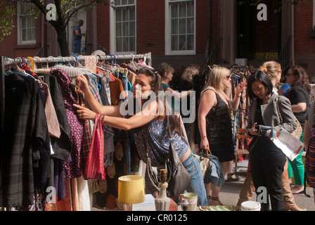 Gli amanti dello shopping ricerca di occasioni a Jane blocco Street Fair in New York quartiere di Greenwich Village Foto Stock