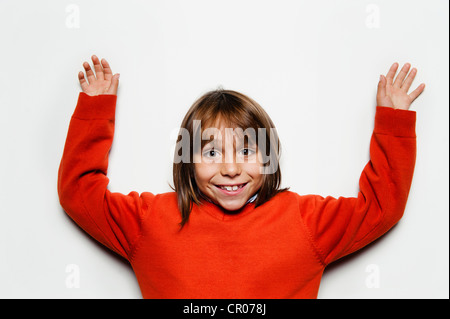 Ragazzo sorridente tenendo le braccia in alto Foto Stock