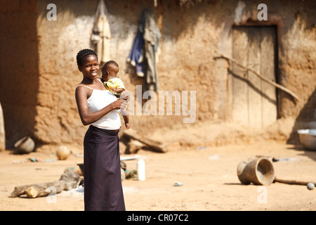 Una donna porta un bambino nel villaggio di Kirkpadouo, regione di Zanzan, Costa d'Avorio il sabato 26 novembre, 2011. Foto Stock
