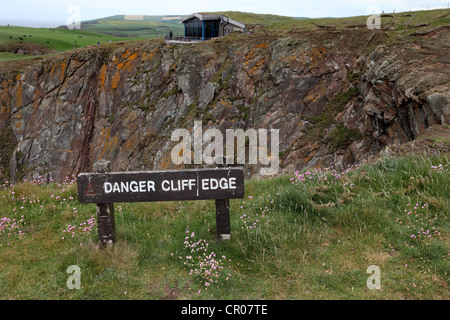 Pericolo bordo scogliera a segno con il promontorio di Galloway Visitor Centre in background Scotland Regno Unito Foto Stock