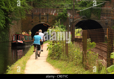 Una vista di un ponte con due archi - quella che attraversa una stazione ferroviaria e l'altro attraversamento di un canale in Birmingham - i ciclisti sul percorso Foto Stock