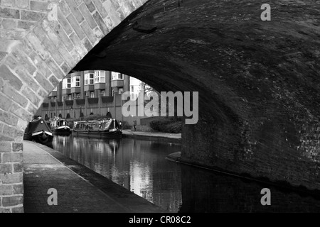 Vista sotto un ponte di barche del canale e gli edifici sul lato opposto - Canal è in Birmingham Foto Stock