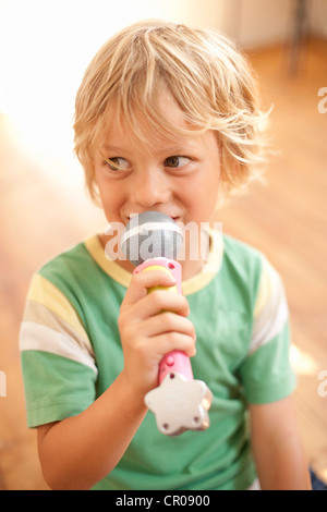 Sorridente ragazzo giocando con microfono giocattolo Foto Stock