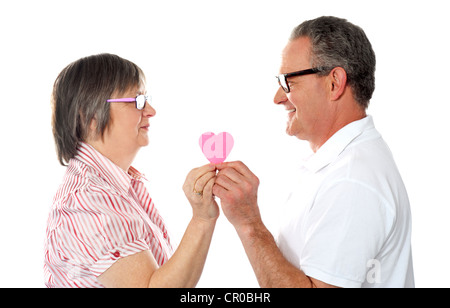 Ritratto di una bella età giovane azienda cuore di carta e sorridente ad ogni altro Foto Stock