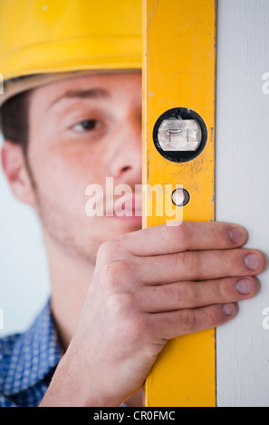 Giovani tradesman utilizzando una livella a bolla Foto Stock