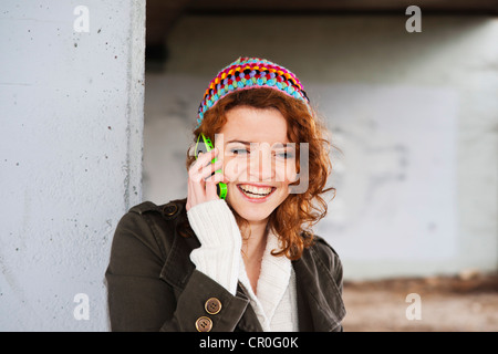 Ragazza sorridente a parlare su un telefono mobile Foto Stock