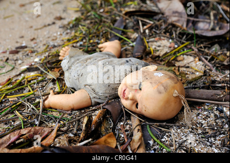 Vecchio broken doll giacente nello sporco sul terreno Foto Stock