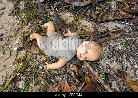 Vecchio broken doll giacente nello sporco sul terreno Foto Stock