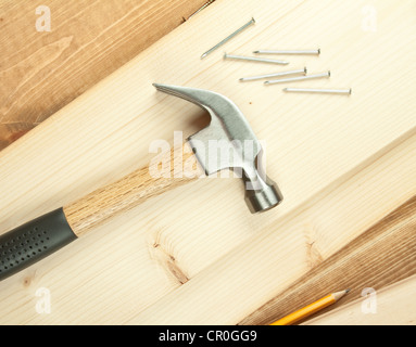 Martello e chiodi su uno sfondo di legno. Foto Stock