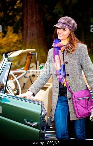 Giovane donna di fronte a post-guerra auto classica Foto Stock