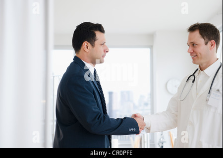 Imprenditore stringono le mani con medico Foto Stock