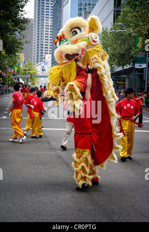 Il cinese la danza del leone di coppie di ballerini condividono un costume di lion durante questo molto energico danza, parte di una street parade. Foto Stock