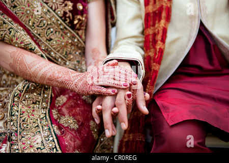 Sposa e lo sposo in indiana tradizionale abbigliamento nozze con Henna Tattoos. Foto Stock