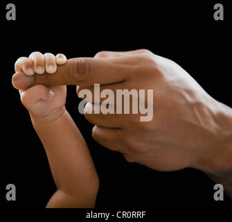 Padre tenendo le mani con il neonato Foto Stock