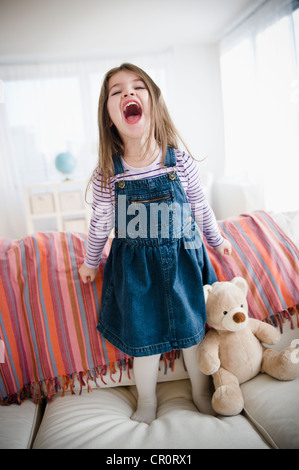 Stati Uniti d'America, New Jersey, Jersey City, piccola ragazza (4-5 anni) in piedi sul divano Foto Stock