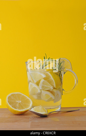 Pezzi di limone, il rosmarino, il succo di limone, limone Tè, vetro Foto Stock