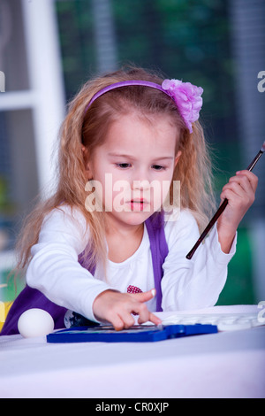 Bambina di pittura delle uova di Pasqua Foto Stock