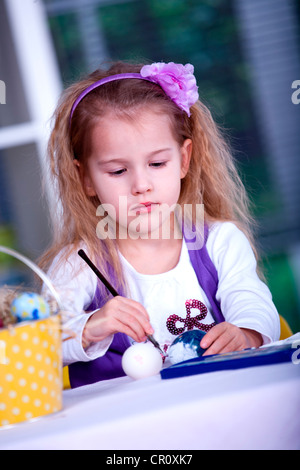 Bambina di pittura delle uova di Pasqua Foto Stock