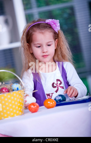 Bambina di pittura delle uova di Pasqua Foto Stock