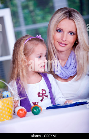 Bambina di pittura delle uova di Pasqua con la sua madre Foto Stock