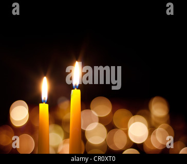 Giallo candele accese nella notte con bokeh di fondo nel buio , abstract Natale sfondo romantico Foto Stock