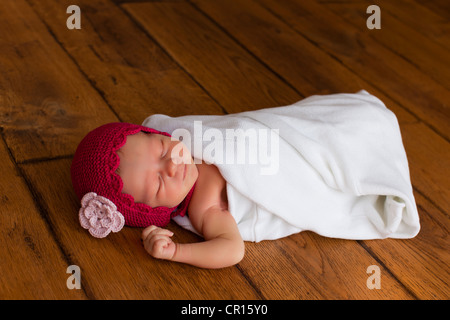 Neonato ragazza, due settimane, con un piccolo cappuccio rosso Foto Stock