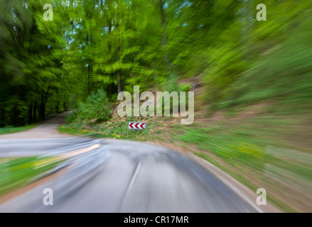 Alta velocità moto, strada di campagna in una zona boscosa con una brusca svolta a sinistra, Germania, Europa PublicGround Foto Stock