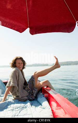 Donna rilassante in barca sul lago ancora Foto Stock