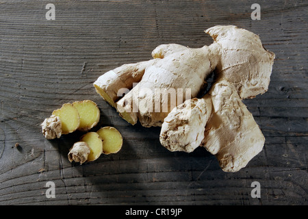 Lo zenzero (Zingiber officinale) Rizoma su un rustico di una superficie di legno Foto Stock