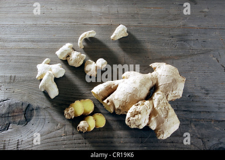 Lo zenzero (Zingiber officinale) Rizoma su un rustico di una superficie di legno Foto Stock