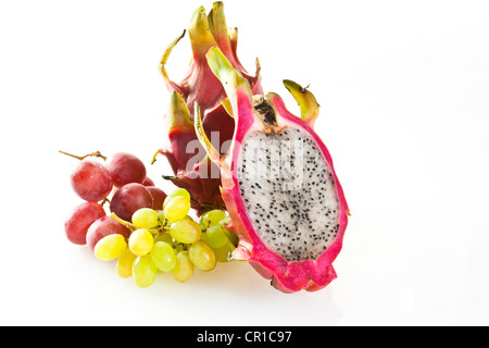 Red pitaya o frutto del drago (Hylocereus undatus) con uve bianche e rosse Foto Stock