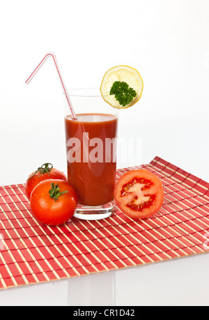 Il succo di pomodoro in un bicchiere con pomodori e limone Foto Stock