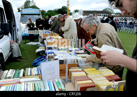 Navigando attraverso la seconda mano libri sport su uno stallo a Horsham cricket club SUSSEX REGNO UNITO Foto Stock