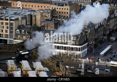 Ore una pistola essendo sparati, circondato da fuochi d'artificio pronto per il Festival Display, al Castello di Edimburgo, Scozia. Foto Stock