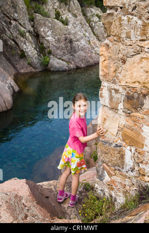 7-anno-vecchia ragazza alla Genovese vecchio ponte di pietra sul fiume di fango, Fango Valley, Corsica, Francia, Europa Foto Stock