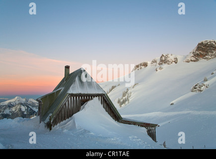 Neve impilate da casa sulla collina Foto Stock