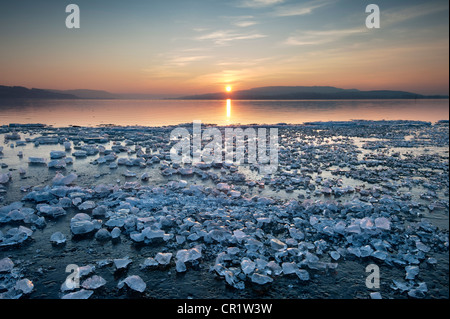 Pezzi di ghiaccio che giace sulla superficie ghiacciata sulla riva di Reichenau isola al tramonto, Baden-Wuerttemberg, Germania, Europa Foto Stock