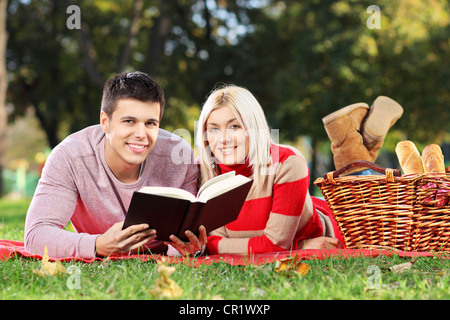 Un amorevole matura la lettura di un libro durante un picnic nel parco della città Foto Stock