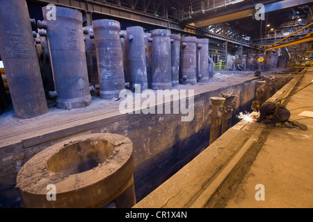 Saldatrice a lavorare nella fucina di acciaio Foto Stock