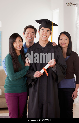 Stati Uniti, California, Los Angeles, Ritratto di giovane uomo in abito di graduazione con la famiglia Foto Stock