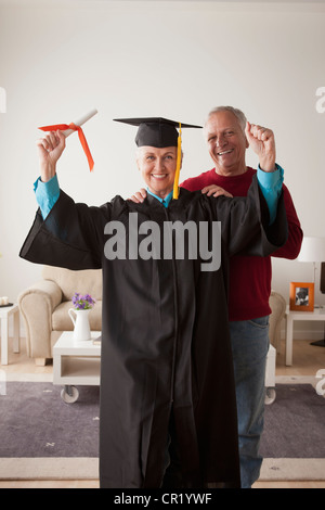 Stati Uniti, California, Los Angeles, Senior donna che indossa la laurea vestaglia uomo felice in background Foto Stock