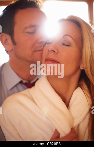 L'uomo baciando la fidanzata in ambienti interni Foto Stock