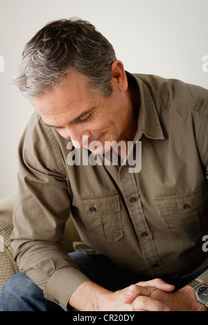 Stati Uniti, California, Los Angeles, preoccupato uomo maturo seduto sul divano Foto Stock