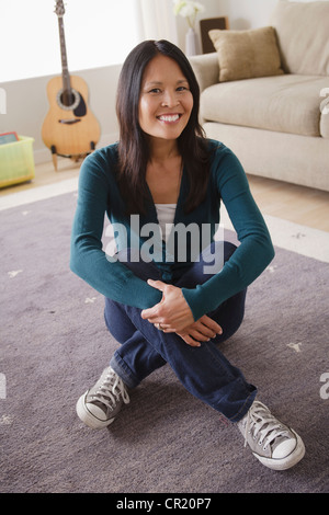 Stati Uniti, California, Los Angeles, sorridente donna seduta sul pavimento Foto Stock