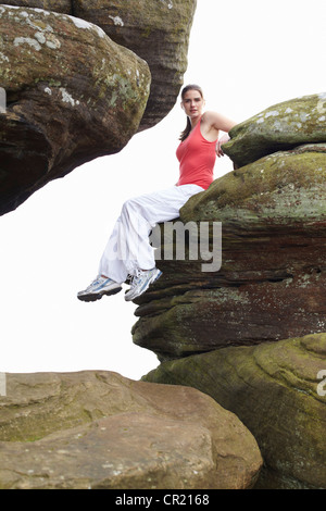 Donna seduta sulle formazioni rocciose Foto Stock